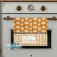 Towel with pumpkin pattern hanging on a stove door