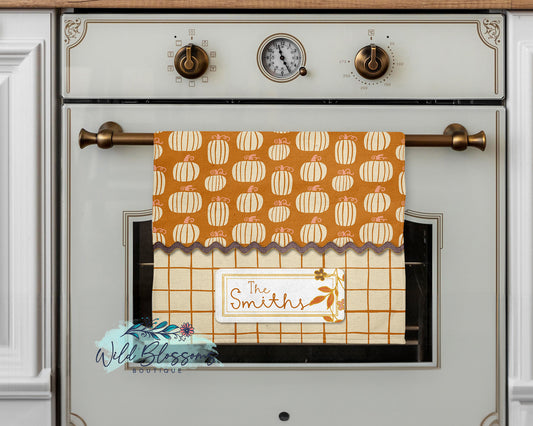 Towel with pumpkin pattern hanging on a stove door