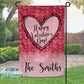 Valentine's Day-themed garden flag with heart design and 'Happy Valentine's Day!' text, displayed outdoors.