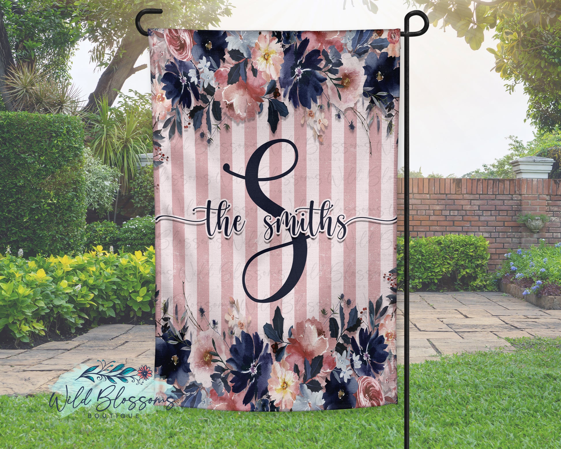 Floral garden flag with 'the smiths' text and striped pattern in a garden setting.