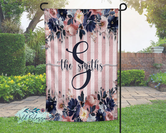 Floral garden flag with 'the smiths' text and striped pattern in a garden setting.