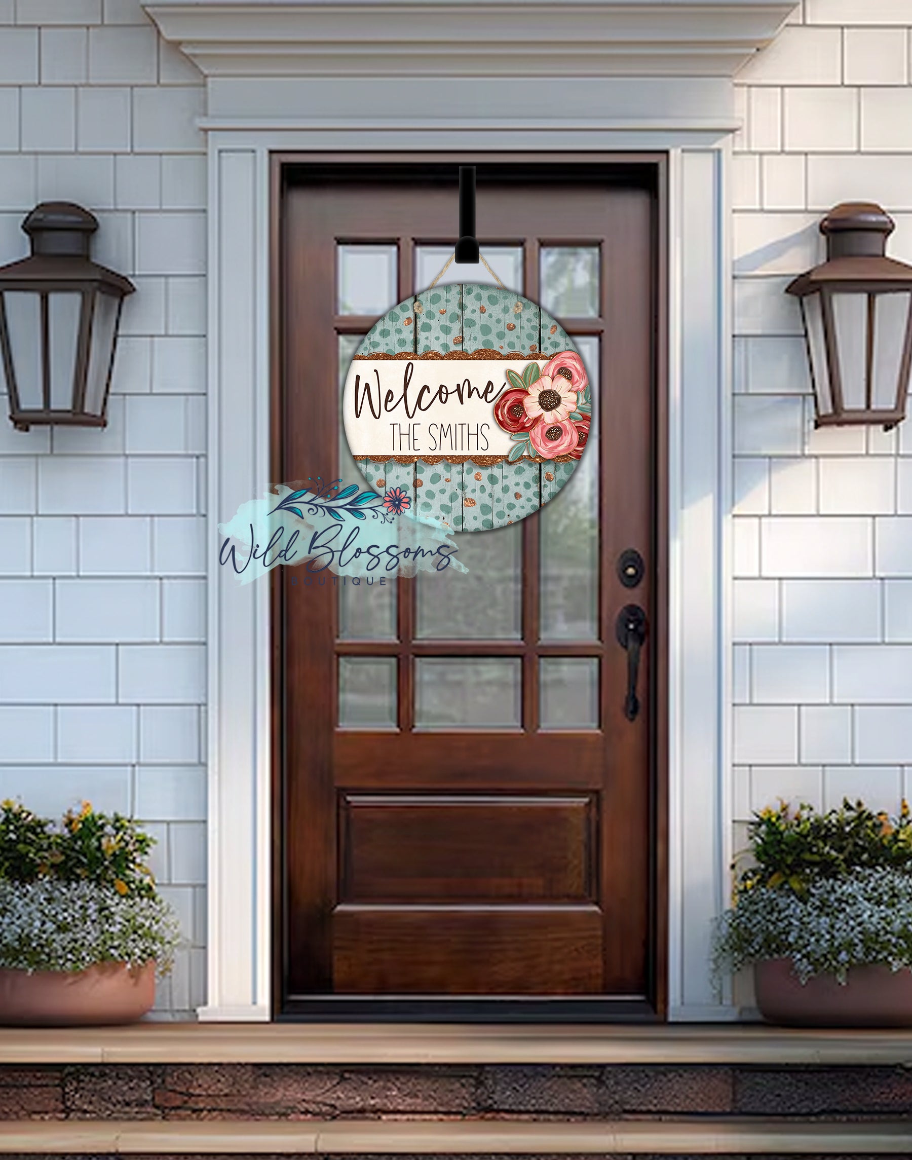 Decorative door sign with floral design and text on a wooden front door.