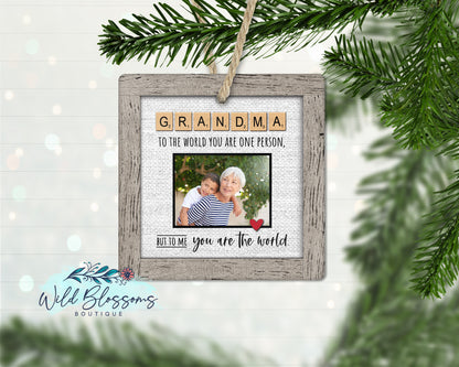 A personalized Scrabble tile photo ornament with the text 'GRANDMA' and a space for a photo, hanging from a string.